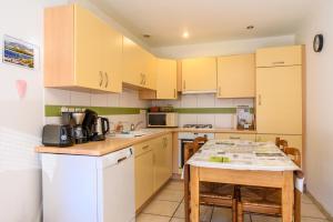 a kitchen with yellow cabinets and a table with chairs at Le Gîte À Mamie in Orbey +19 photos