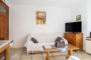 a living room with a white couch and a table at Le Gîte À Mamie in Orbey