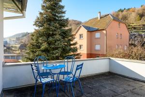 two chairs and a table on a balcony with a tree at Le Gîte À Mamie in Orbey