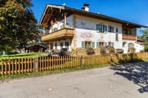 a house with a wooden fence in front of it at Ferienwohnungen am Hofgarten in Krün