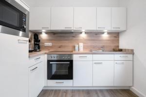 a white kitchen with white cabinets and a sink at Ferienwohung Finsterwalde in Finsterwalde
