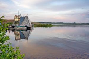 a building on a lake with its reflection in the water at Ferienwohung Finsterwalde in Finsterwalde