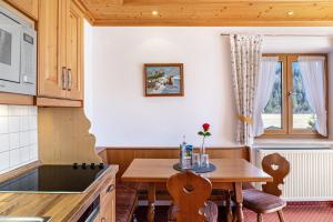 a kitchen with a wooden table and a table at Alpenblick Tilly - Fewo Soiernsee 4 in Krün