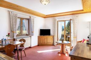 a living room with a tv and some windows at Alpenblick Tilly - Fewo Soiernsee 4 in Krün