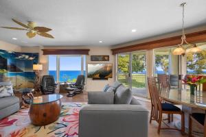 a living room with a table and a dining room at NEW Sunset Cove Hale Breathtaking View Pool AC in Princeville