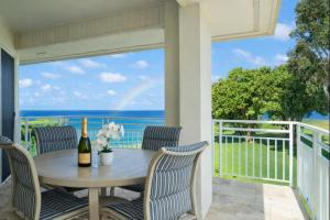 a table and chairs on a balcony with a view of the ocean at NEW Sunset Cove Hale Breathtaking View Pool AC in Princeville +59 photos