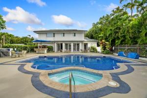 a swimming pool in front of a house at NEW Sunset Cove Hale Breathtaking View Pool AC in Princeville