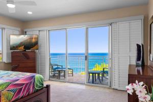 a bedroom with a bed and a view of the ocean at NEW Sunset Cove Hale Breathtaking View Pool AC in Princeville
