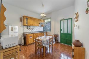 a kitchen with a table and a green door at Apartamento Nayara A in Calera