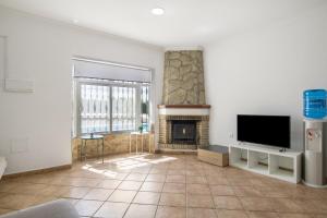 a living room with a fireplace and a flat screen tv at Chalet Independiete Con Piscina in Cádiz