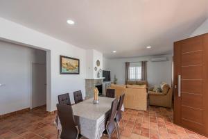 a dining room with a table and chairs and a living room at Casa Brisa del Valle in Seville