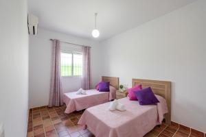 two beds in a room with pink and purple pillows at Casa Brisa del Valle in Seville +33 photos