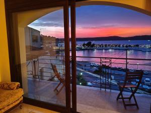 ein Balkon mit Blick auf einen Yachthafen bei Sonnenuntergang in der Unterkunft Pylos before midnight in Pylos