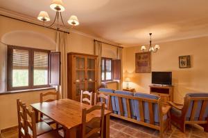 a living room with a wooden table and a dining room at Apartamentos Valsequillo Córdoba in Valsequillo