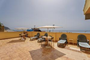 a patio with chairs and tables and umbrellas at Loft Pension Candelaria in Valle Gran Rey