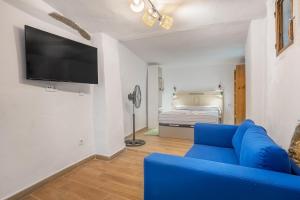 a living room with a blue couch and a bed at Alicia's House in Granada