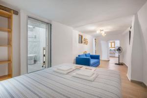 a bedroom with a large bed and a blue chair at Alicia's House in Granada