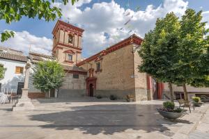 a building with a clock tower in a courtyard at Alicia's House in Granada