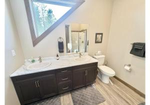 a bathroom with a sink and a mirror and a toilet at Sunny Peaks in Valemount +11 photos