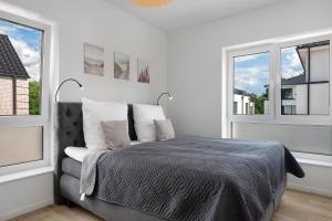 a bedroom with a bed and two windows at Das Strandhaus am Dümmer See in Lembruch