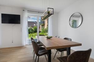 a dining room with a table and chairs and a mirror at Das Strandhaus am Dümmer See in Lembruch