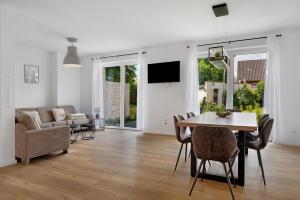 a living room with a table and a couch at Das Strandhaus am Dümmer See in Lembruch