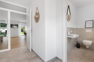 a bathroom with a toilet and a sink at Das Strandhaus am Dümmer See in Lembruch +18 photos