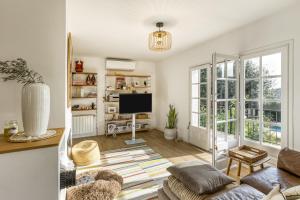 a living room with a couch and a tv at Villa Les Aulines in Calonge