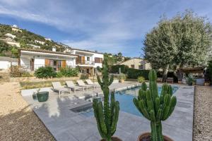 a house with two cactuses and a swimming pool at Villa Les Aulines in Calonge