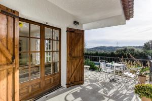 a balcony with a wooden door and a table and chairs at Villa Les Aulines in Calonge