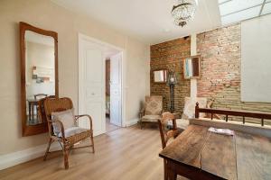 a living room with a wooden table and a brick wall at Appartement Graingalet in Carbonne
