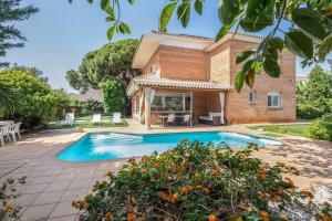 a villa with a swimming pool and a house at Villa Masnou in El Masnou