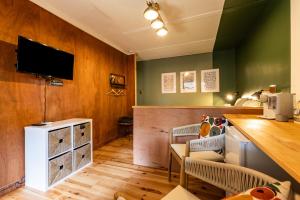 a living room with a tv on a wooden wall at Les Ptis Chiffons in Lacanau