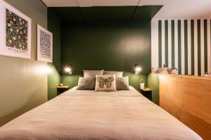 a bedroom with a large bed with green walls at Les Ptis Chiffons in Lacanau +17 photos