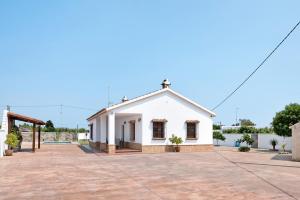 a small white building in a parking lot at Casa Sonia y Nuria in Roche