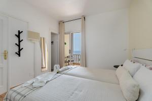 a white bedroom with a bed with a view of the ocean at Loft Pension Candelaria in Valle Gran Rey