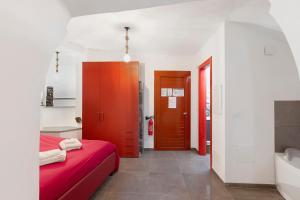 a bedroom with a red bed and a bathroom at Casa vacanza A Cola - con Jacuzzi in Rocchetta Nervina