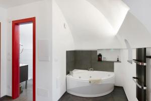 a white bathroom with a white tub in it at Casa vacanza A Cola - con Jacuzzi in Rocchetta Nervina +24 photos