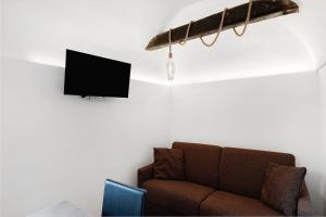 a living room with a couch and a tv on a wall at Casa vacanza A Cola - con Jacuzzi in Rocchetta Nervina