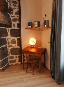 a lamp sitting on a wooden desk in a room at Maison des Princes de Monaco in Vic-sur-Cère