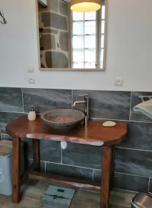 a bathroom with a wooden sink and a mirror at Maison des Princes de Monaco in Vic-sur-Cère