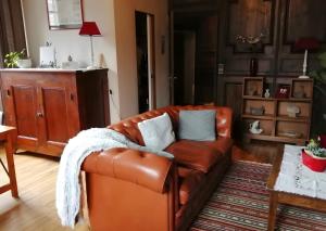 a brown leather couch in a living room at Maison des Princes de Monaco in Vic-sur-Cère