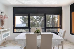 a dining room with a white table and chairs at Villa Can Camarassa in Cervelló