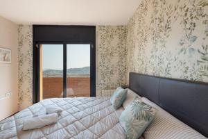 a bedroom with a large bed with a large window at Villa Can Camarassa in Cervelló +28 photos