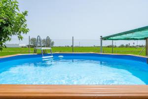 a large swimming pool with a chair in it at Casa Rural Benjamin en Deltebre in Deltebre