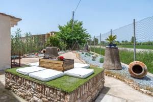 a garden with a stone wall with cushions and plants at Casa Rural Benjamin en Deltebre in Deltebre