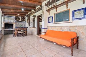 an orange couch in a room with a fireplace at Casa Rural Benjamin en Deltebre in Deltebre