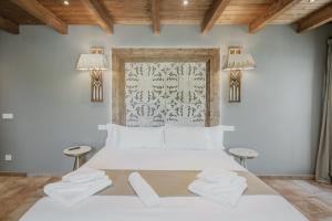 a bedroom with a white bed with two stools at La Antigua Taberna - Nieva in Nieva +34 photos