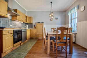 a kitchen with wooden cabinets and a table and chairs at Ferienwohnung Blütenzauber in Sagard