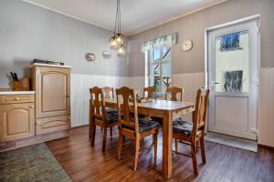 a kitchen and dining room with a wooden table and chairs at Ferienwohnung Blütenzauber in Sagard +8 photos